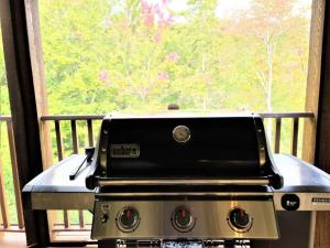 a stove top oven sitting on a porch with a window at Nature's Luxe Retreat - Panache 638 in Mont-Tremblant +26 photos