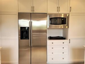 a kitchen with a stainless steel refrigerator and a microwave at Nature's Luxe Retreat - Panache 638 in Mont-Tremblant