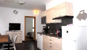 a kitchen with a white refrigerator and a table and a room at Apartment Draco in Harrachov