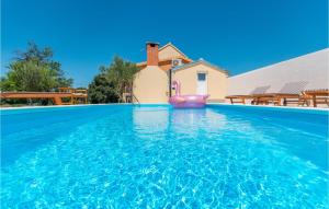 a villa with a swimming pool with a pink inflatable pool toy at 4 Bedroom Stunning Home In Polaca in Polača