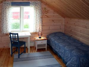a bedroom with a bed and a desk and a window at Lomakivi in Kausala