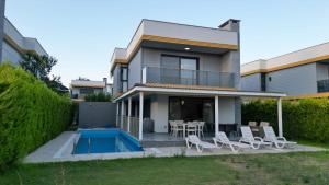 a house with a patio and a swimming pool at ÖZEL HAVUZLU Müstakil LÜKS VILLA in Kusadası