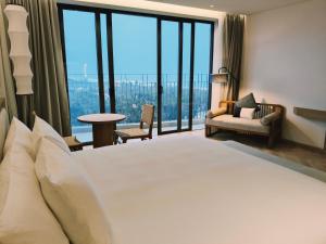 une chambre avec un grand lit et de grandes fenêtres dans l'établissement Luxstay apartment Swimming pools and private beach, à Dien Ban 42 autres photos