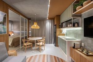 a kitchen and living room with a table and a bedroom at Studio Bali, aconchego e luxo. in Campo Grande