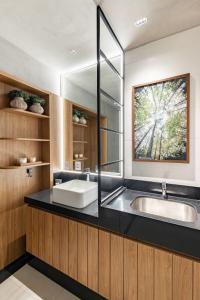 a bathroom with a sink and a mirror at Studio Bali, aconchego e luxo. in Campo Grande