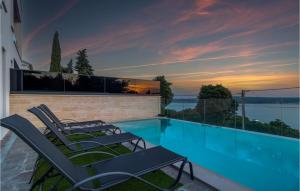 a group of chairs sitting next to a swimming pool at Gorgeous Home In Dramalj in Dramalj +37 photos