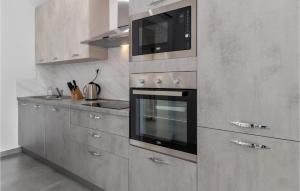 a kitchen with a stove and a microwave at Gorgeous Home In Dramalj in Dramalj