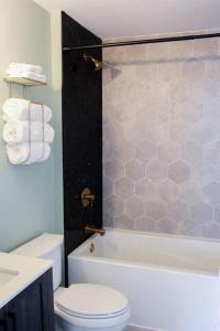 a bathroom with a toilet and a tub and a sink at Romantic Waterfront Sunset Views in PEC in Belleville