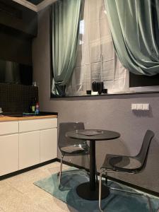 a table and chairs in a room with a window at City Apartments Trier-Karl-Marx Suite 1 in Trier +7 photos