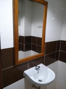 uma casa de banho com um lavatório e um espelho em Phoonsab Hostel em Phitsanulok