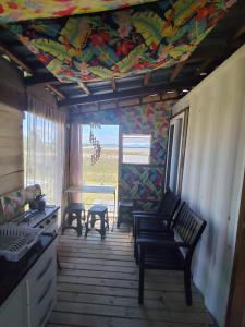 インベーにあるDunas da Imara Casa Brisaの天井に絵が描かれ、椅子とテーブルが置かれた部屋