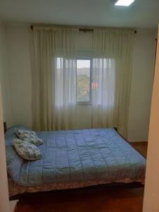 a bed in a bedroom with a window at vistas del valle in Villa Carlos Paz +15 photos