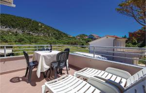 a table and chairs on a balcony with a view at 1 Bedroom Beautiful Apartment In Barbat in Barbat na Rabu +19 photos