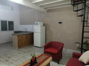 a kitchen with a white refrigerator and a red chair at Coco's Bamboo in General Pacheco