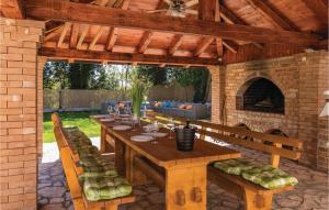 a wooden table and chairs in a patio with a fireplace at Gorgeous Home In Bibici With Sauna in Bibići