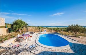 basen na dziedzińcu z krzesłami i stołem w obiekcie Two-Bedroom Holiday Home In Vrana w mieście Vrana