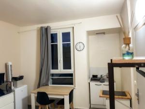 a room with a table and a clock on a window at Studio SN4 - Centre-Ville Meaux - Proche Disneyland in Meaux