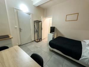 a bedroom with a bed and a table with chairs at Studio SN4 - Centre-Ville Meaux - Proche Disneyland in Meaux