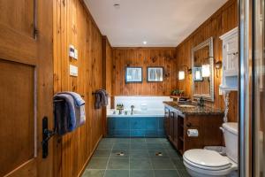 e bagno con pareti in legno, vasca e servizi igienici. di Private Hot & ski in ski out - Altitude 170-1 a Mont-Tremblant Altre 18 foto