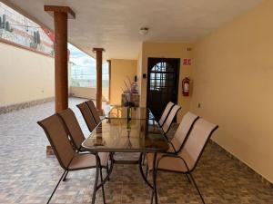 a dining room with a glass table and chairs at Casa La Gladiola para 8 personas con terraza, Asador y WiFi in Ezequiel Montes
