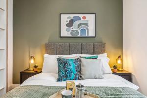 a bedroom with a bed and two tables with lamps at Ultra-Luxury Modern Apartment with Gym, Cinema, Game Room and Parking in Kew Bridge