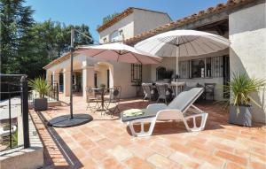 a patio with two umbrellas and chairs and a table at Awesome Home In Les Adrets D L'estérel in St Jean de l’Esterel +32 photos