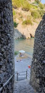 a beach with an umbrella and people in the water at B&B DieMme Amalfi Coast in Vietri sul Mare
