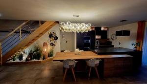 a kitchen with a dining table and a chandelier at Villa Croisette in Pruillé-le-Chétif