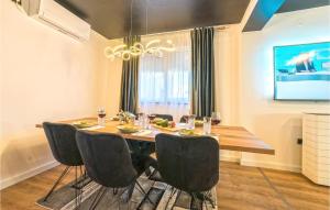 a dining room with a wooden table and black chairs at Beach Front Home In Vir in Vir