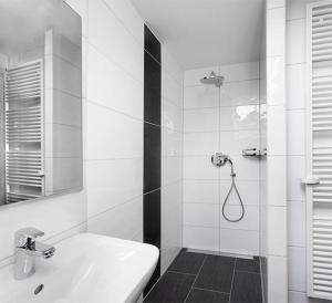 een witte badkamer met een wastafel en een douche bij Das Gästehaus Eimeldingen in Eimeldingen +9 foto's