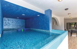 a large swimming pool with a blue wall at Nice Home In Bribir With Sauna in Bribir