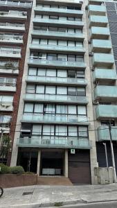 Un edificio de apartamentos con un estacionamiento enfrente. en Studio Park, en Montevideo 12 fotos más