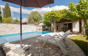 a pair of chairs and an umbrella next to a pool at Amazing Home In Vinjani Donji in Imotski