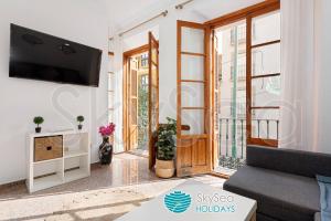 un soggiorno con un divano e una TV di Casa TIPICA MALAGUEÑA con PATIO en el centro a Málaga