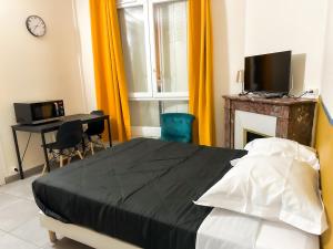 a bedroom with a bed and a desk and a television at Studio SN2 - Centre-Ville Meaux - Proche Disneyland in Meaux