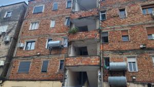 un vecchio edificio in mattoni con finestre e condizionatori d'aria di Emmas Place- Apartamenti modern por miqesor ne qender te Elbasanit a Elbasan