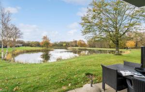 HeeにあるHoliday Home Dyrefolden Ringkøbing Denmの池の横の公園のピクニックテーブル