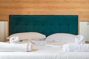 a bed with white sheets and towels on it at Eldo Paradise in Durrës