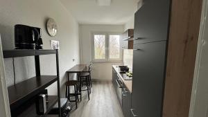 a small kitchen with a refrigerator and a table at MiCasa TuCasa - 3-R Apartment Leipziger Neuseenland Nova in Kitzscher