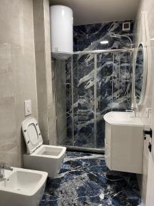 a bathroom with a toilet and a sink and a shower at Central Apartment - 2 Bedroom in Tirana