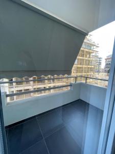 a balcony with chairs and a view of a building at Central Apartment - 2 Bedroom in Tirana