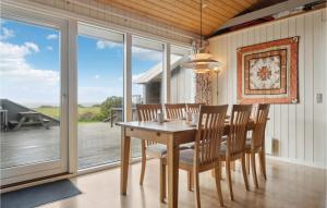 a dining room with a wooden table and chairs at Stunning Home In Vestervig With Sauna in Vestervig
