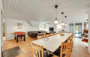 a dining room and kitchen with a large table and chairs at Beautiful Home In Ulfborg With Sauna in Øby