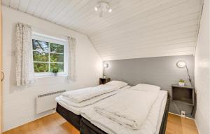 a bedroom with a large bed in a room with a window at Beautiful Home In Ulfborg With Sauna in Øby
