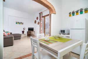 a dining room and living room with a table and chairs at Casa Murru & Sale in Irgoli