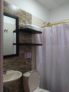 ein Badezimmer mit Toilette, Waschbecken und Spiegel in der Unterkunft SAES Hotel Boutique in El Banco