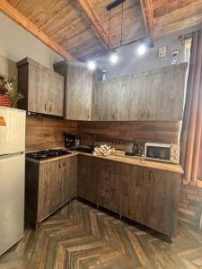 a kitchen with wooden cabinets and a white refrigerator at Home N 57 in Dilijan