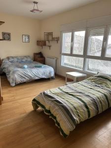 a bedroom with two beds and a window at Casita Azul Homestay in Cáseda