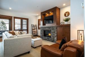 Una sala de estar con un sofá y una chimenea. en Spacious condo on the SLOPES - ETOILE 1510-4, en Mont-Tremblant