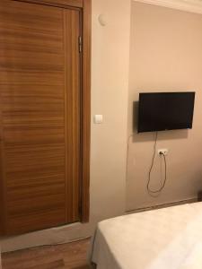 a room with a television on a wall next to a bed at LAVİNYA PENSİON in Kusadası +27 photos